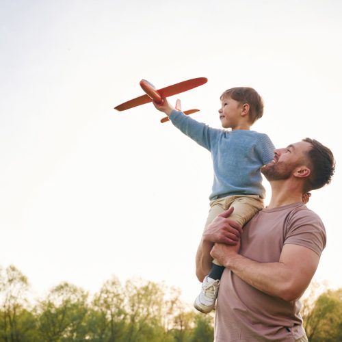 Father,Is,Holding,Son,That,Playing,With,Toy,Plane.